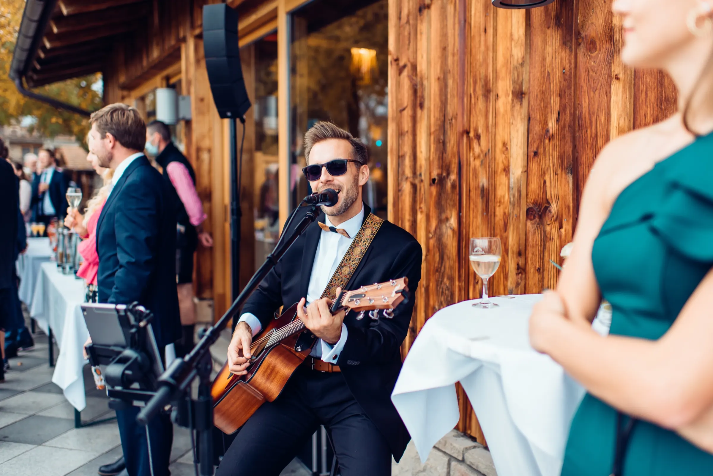 Live-Musik beim sommerlichen Empfang vor einer Holzfassade